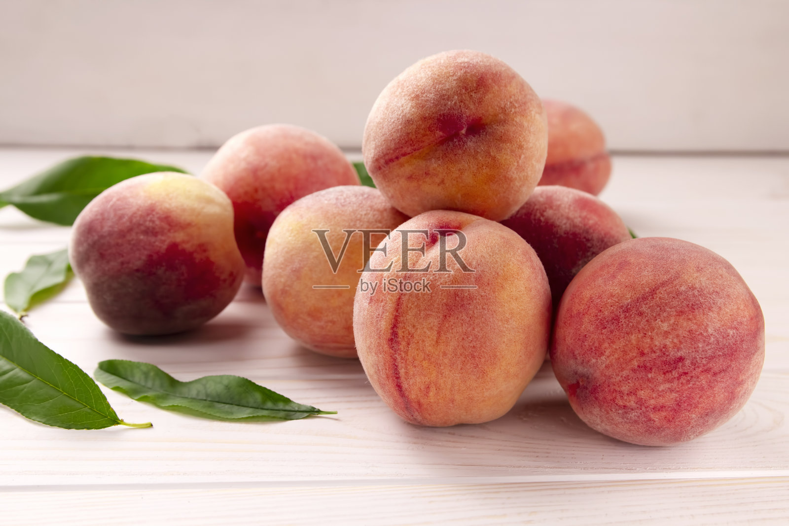 木桌上放着新鲜的桃子。夏日桃果背景。照片摄影图片