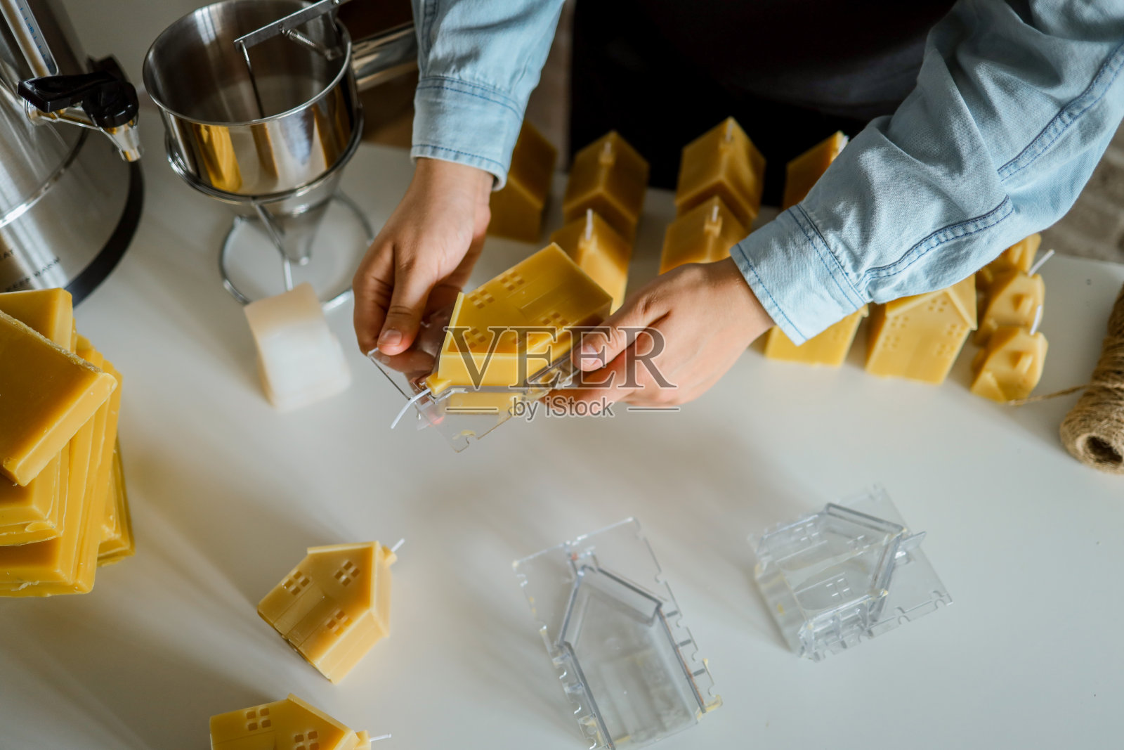 制作蜡烛的创造性活动。女人用蜂蜡制作蜡烛,制作照片摄影图片