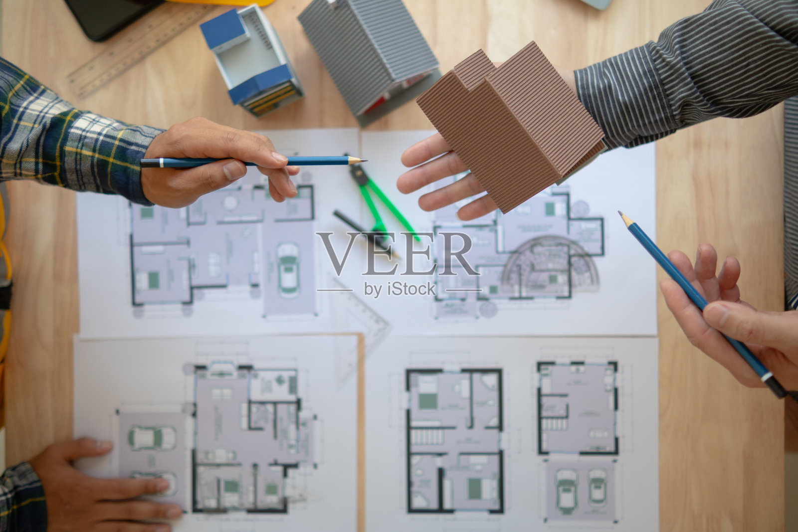 建筑工程师与建筑师讨论和交流意见,以改善房屋规划,以满足客户的需求。建筑工程师和建筑师之间交流设计思想的概念。照片摄影图片