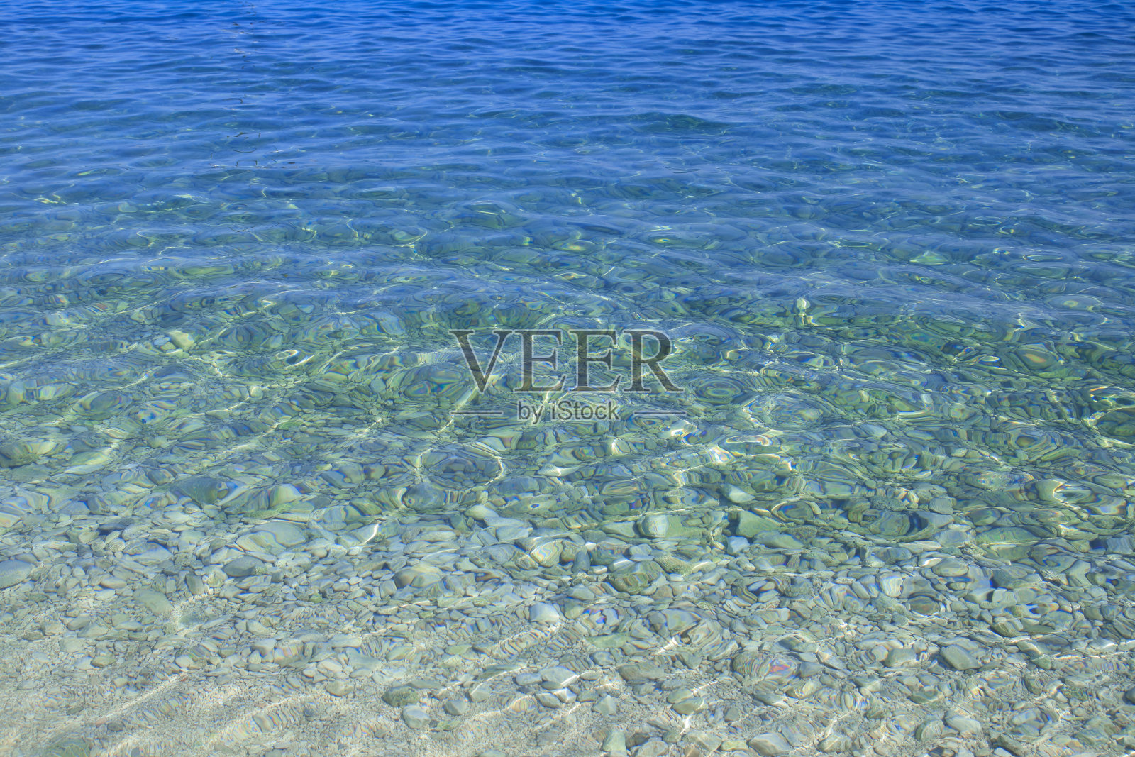 阳光明媚的水波和底部的石头。暑假。抽象水面。水波背景。水波与闪亮的图案纹理背景。海照片摄影图片