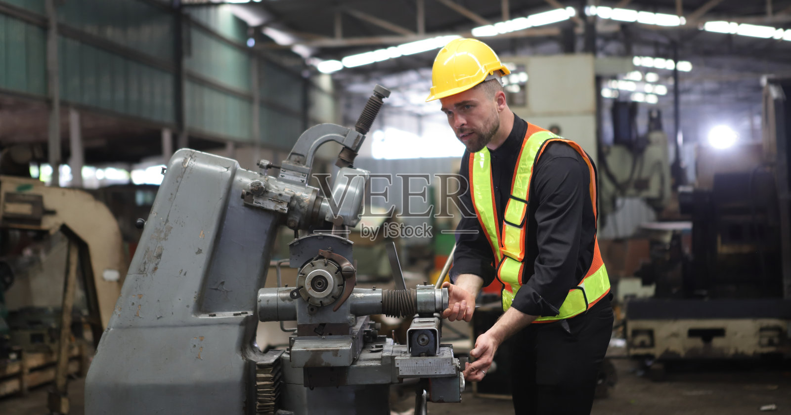 在工厂工作的工人或工程师穿着安全制服,安全帽和安全眼镜,形象是安全理念或快乐的工作场所照片摄影图片