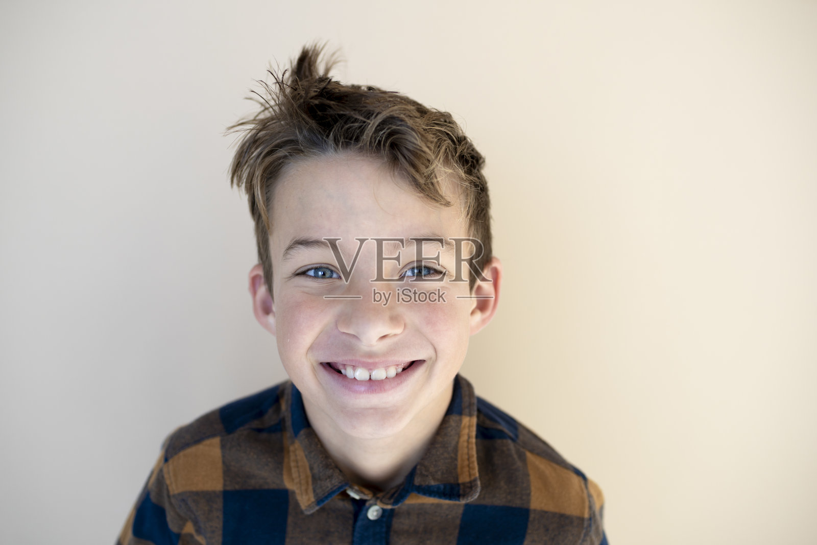 很酷的小男孩站在棕色背景前照片摄影图片