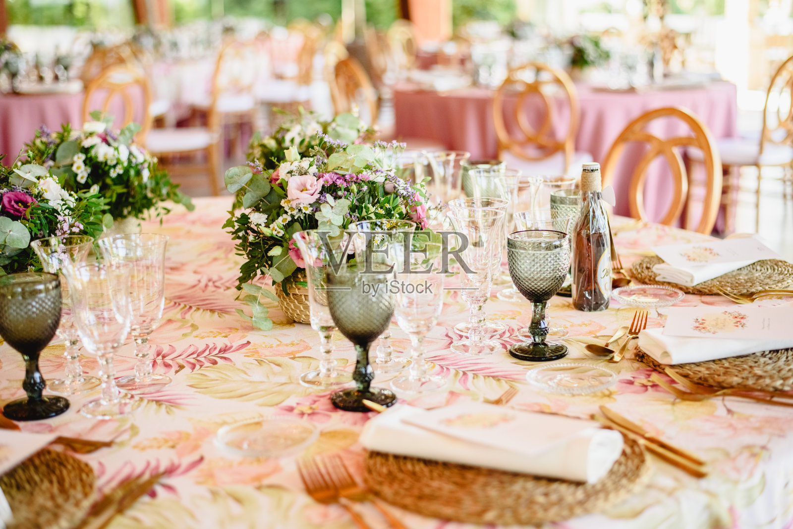 优雅的餐具和花卉安排在婚礼餐厅的桌子与复古风格的中心。照片摄影图片