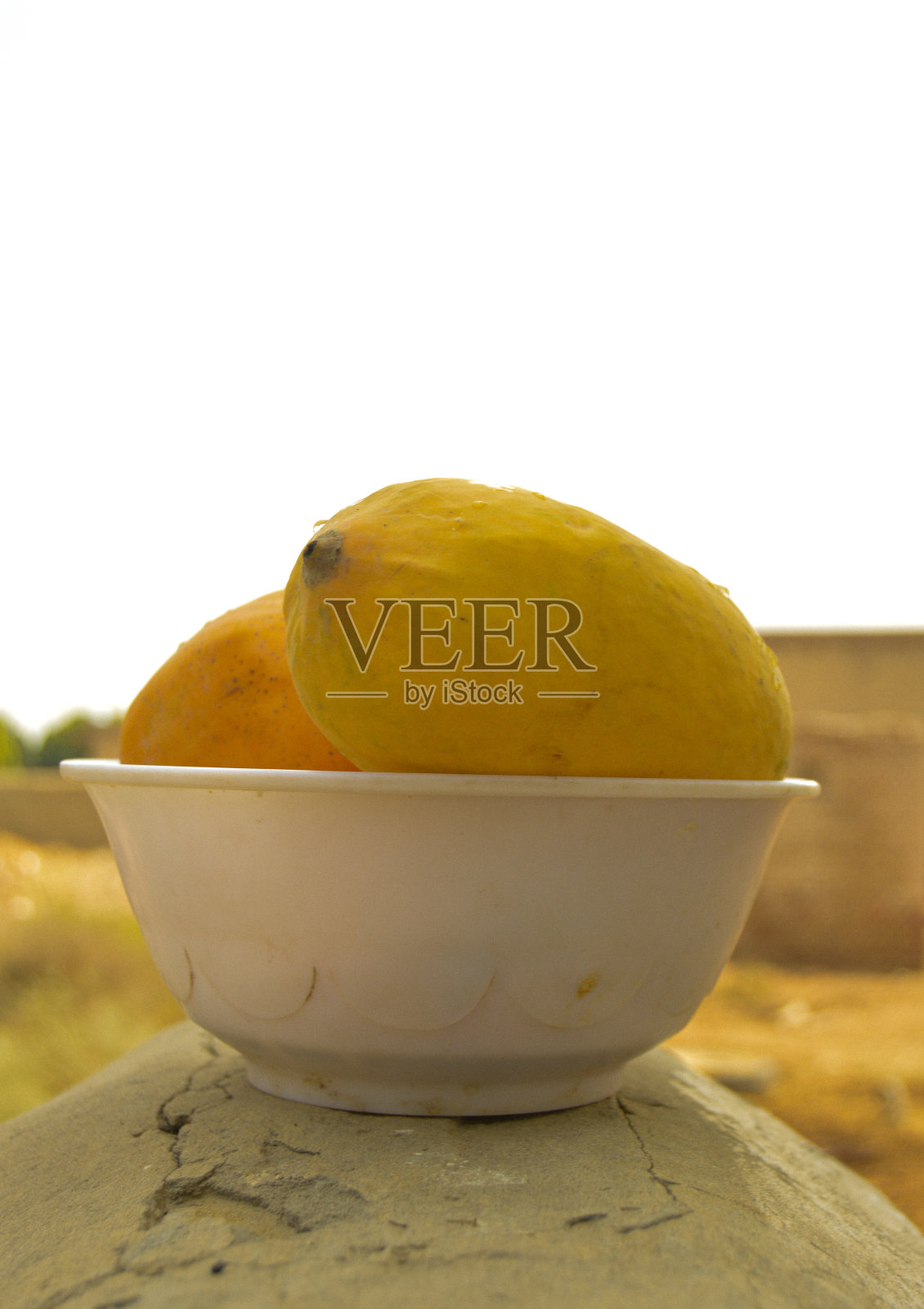 一名男子手持柳条篮子,篮子里装着美味的芒果。黄色芒果的特写。满满一篮子成熟的黄色芒果。新鲜成熟的芒果堆在篮子里。亚洲的芒果。照片摄影图片