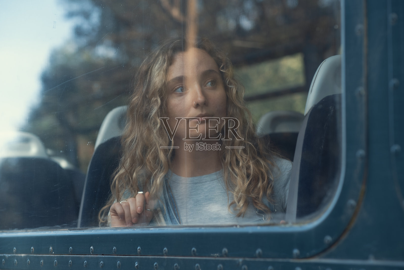年轻女子透过火车窗户往外看照片摄影图片