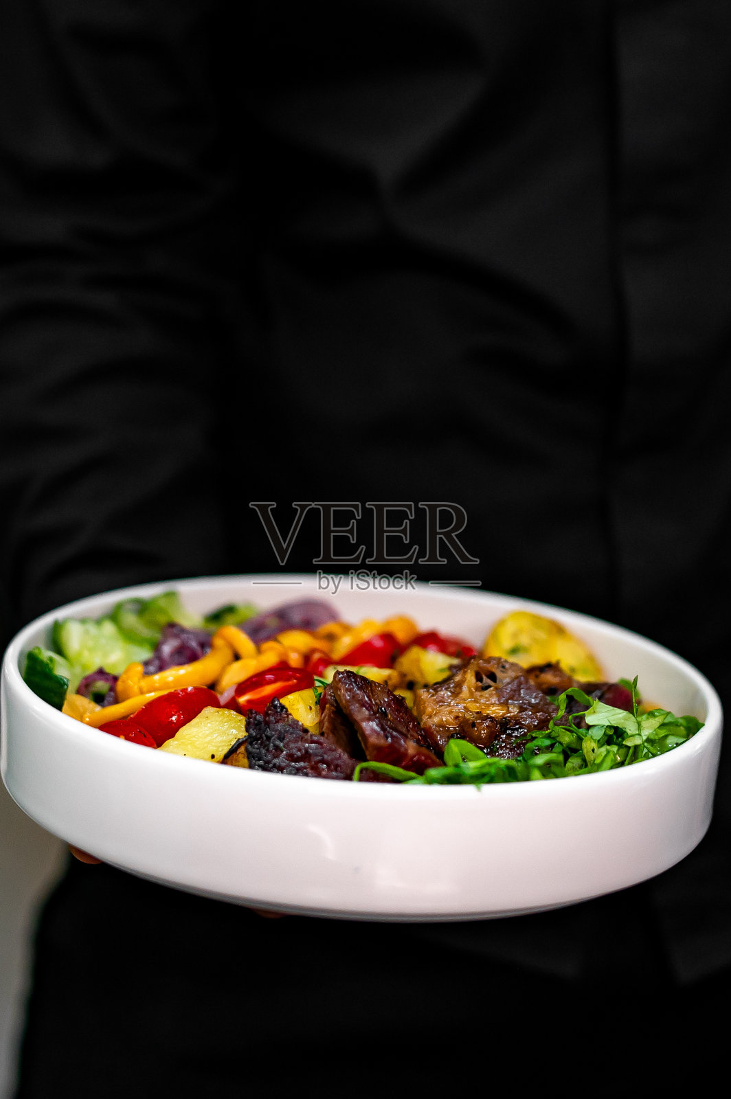 厨师或服务员端着一盘科布沙拉照片摄影图片