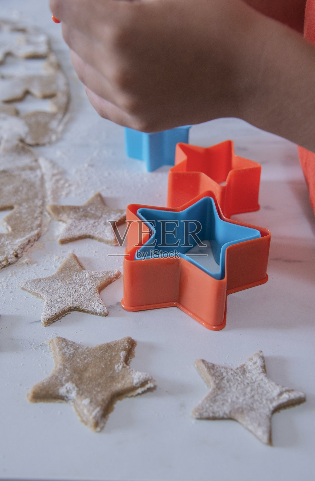 小孩的手拿着星星形状的饼干。照片摄影图片