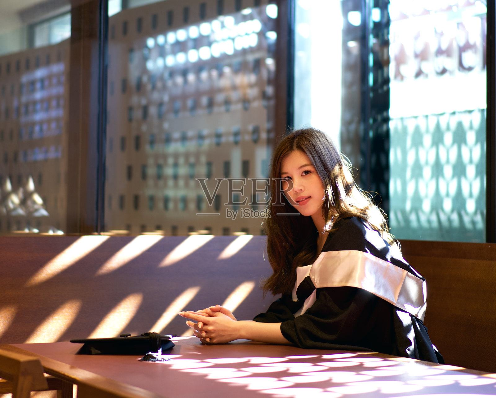 快乐的年轻女子在大学校园户外拍摄肖像,穿着毕业礼服,庆祝学业成就的亚洲美丽国际学生照片摄影图片