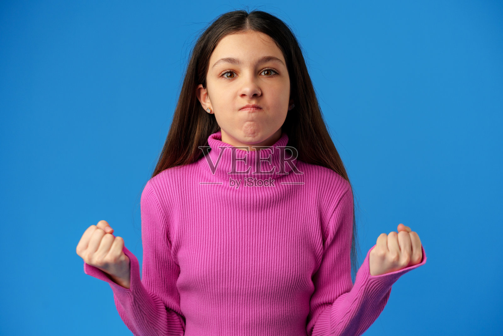 一个快乐快乐的十几岁的女孩庆祝成功的蓝色背景的肖像照片摄影图片