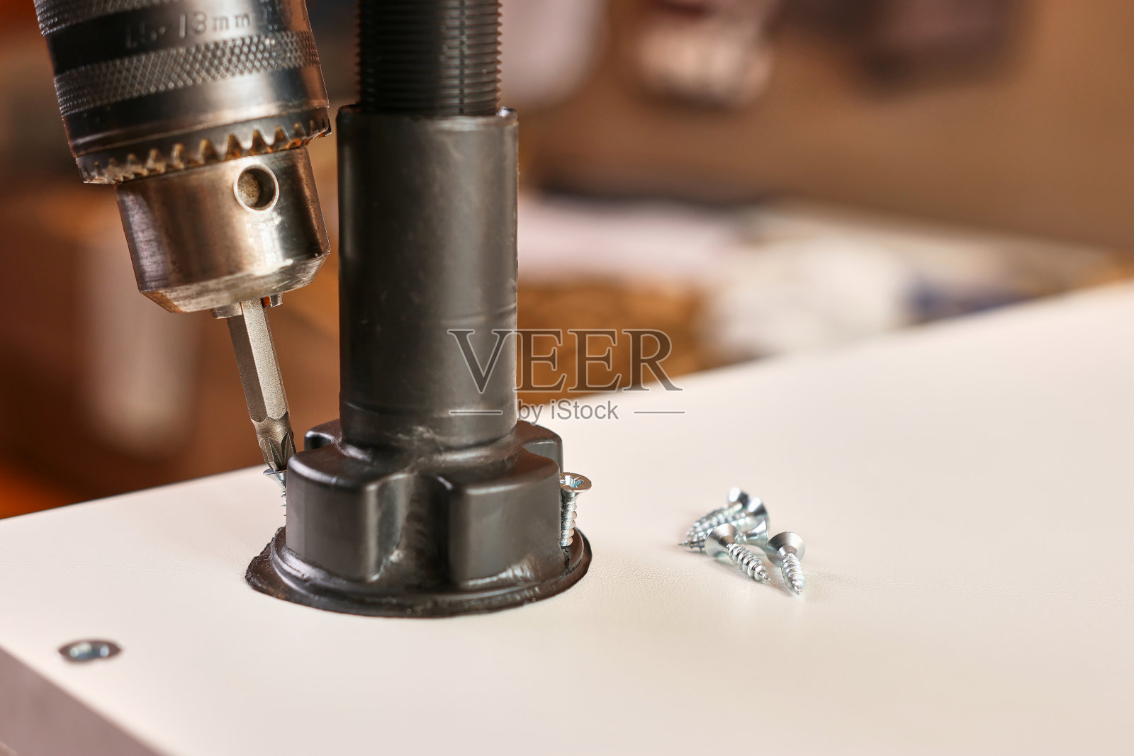 家具腿是用螺丝刀固定的。组装橱柜家具。照片摄影图片