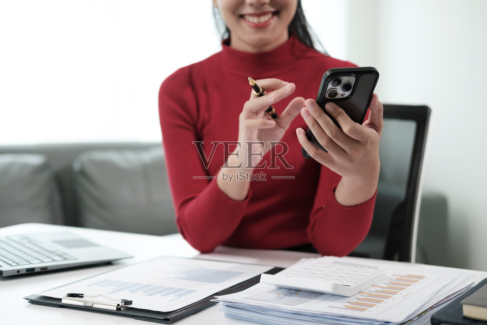 女商人在办公桌旁使用智能手机照片摄影图片