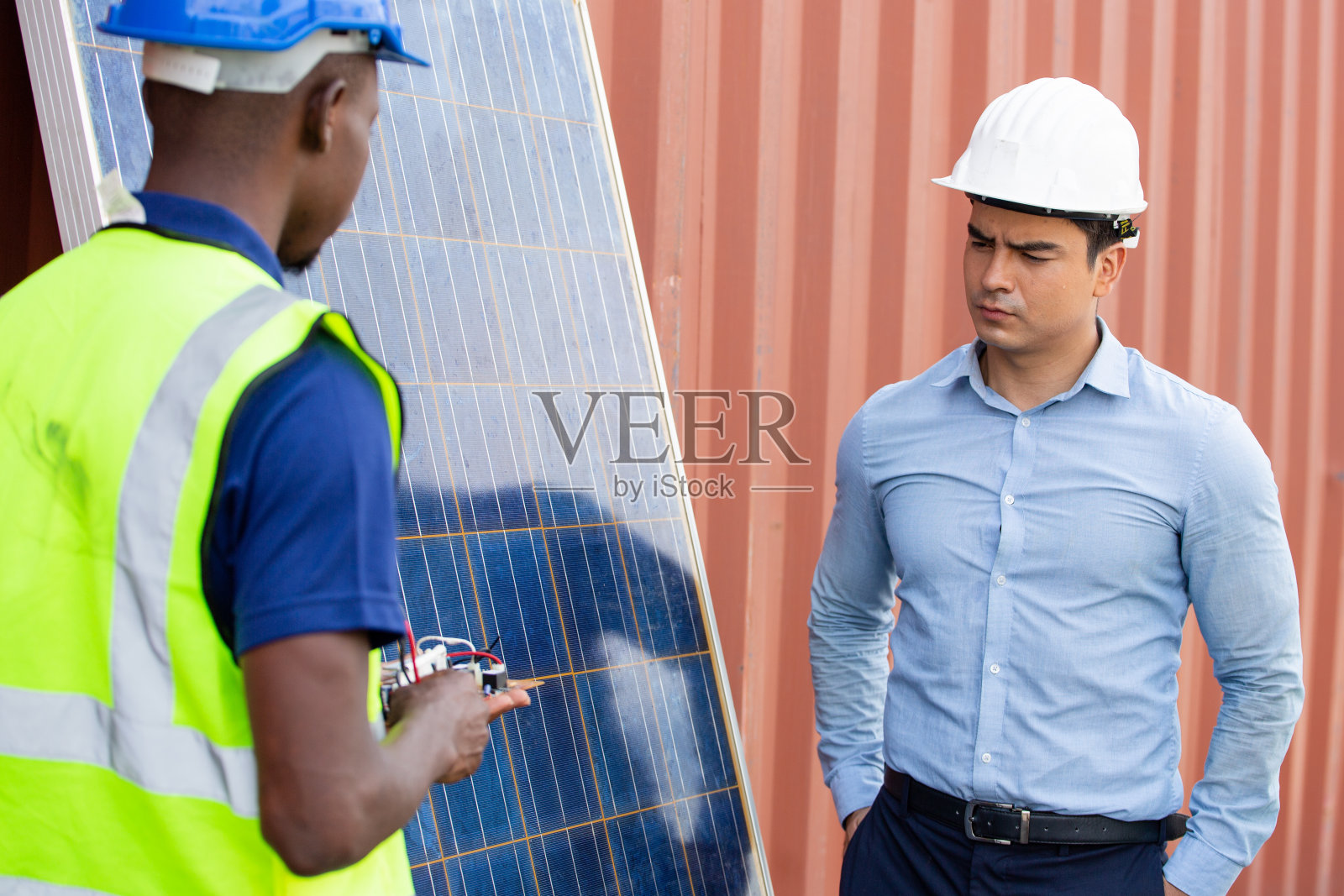 工程师向客户或团队同事展示太阳能电池板。清洁能源和节能工程照片摄影图片