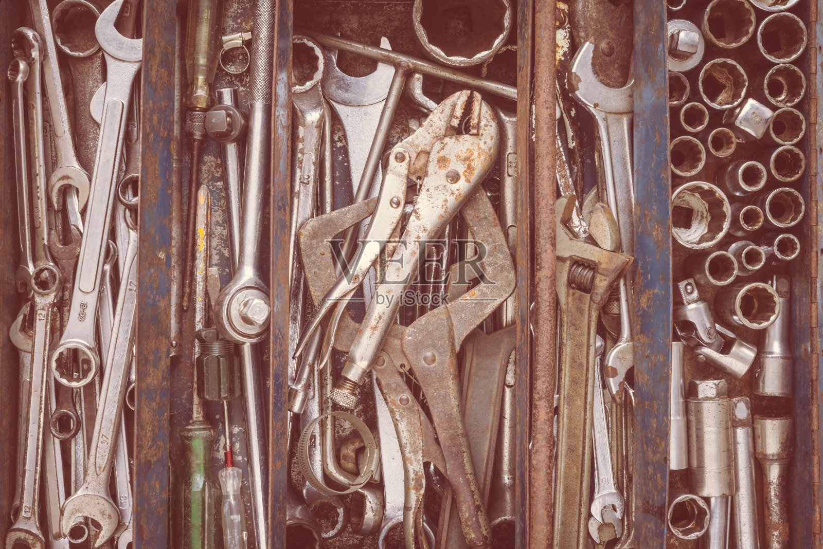 许多用过的工具摆放在简陋的工具箱里。照片摄影图片