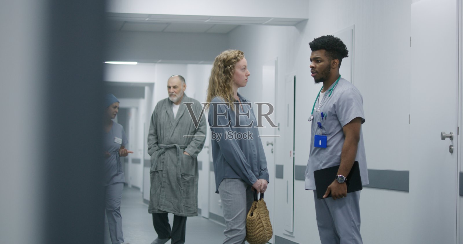 非裔美国医生和一名妇女站在医院走廊上照片摄影图片