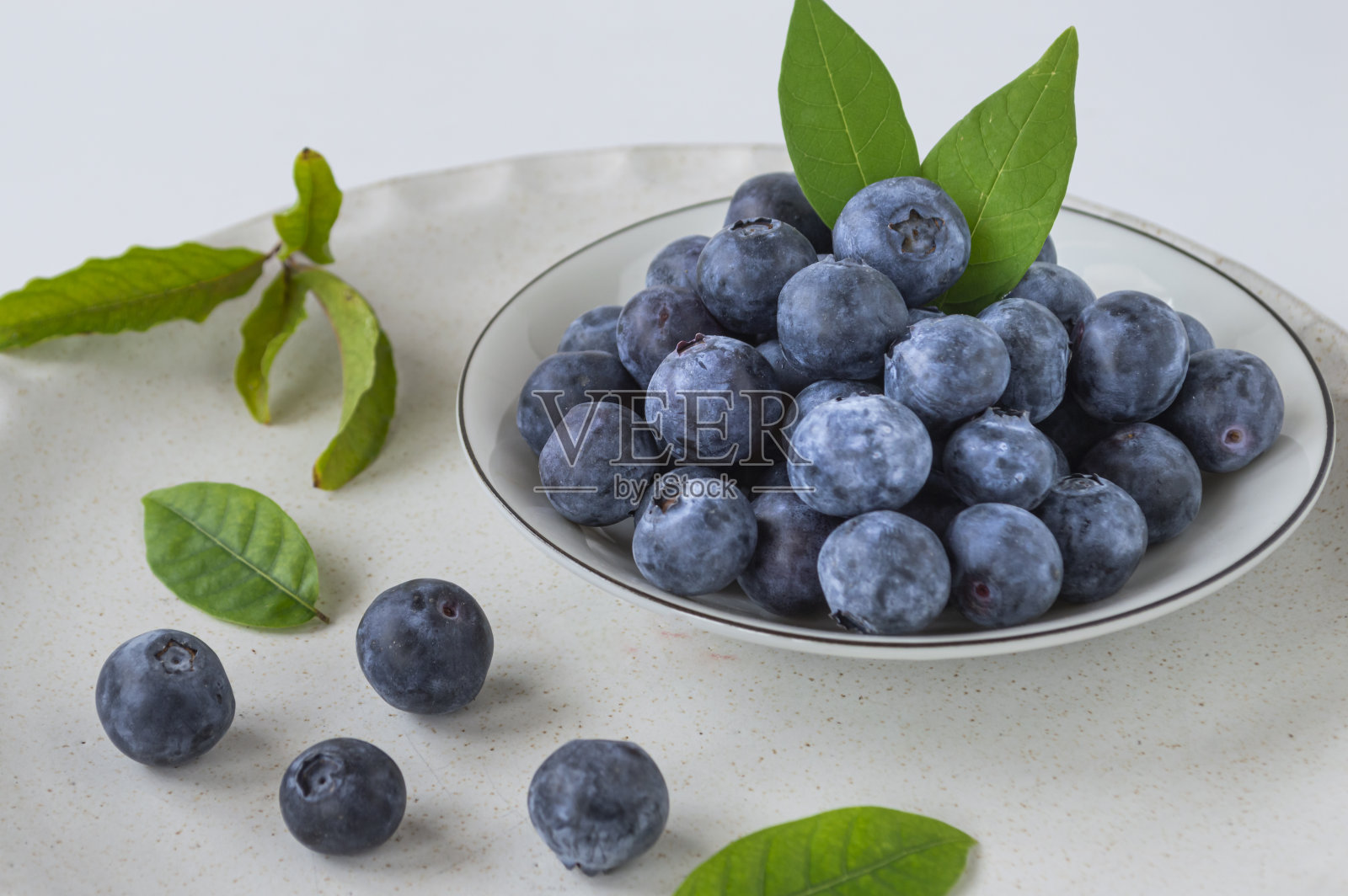 盘子里放着新鲜的紫色蓝莓照片摄影图片
