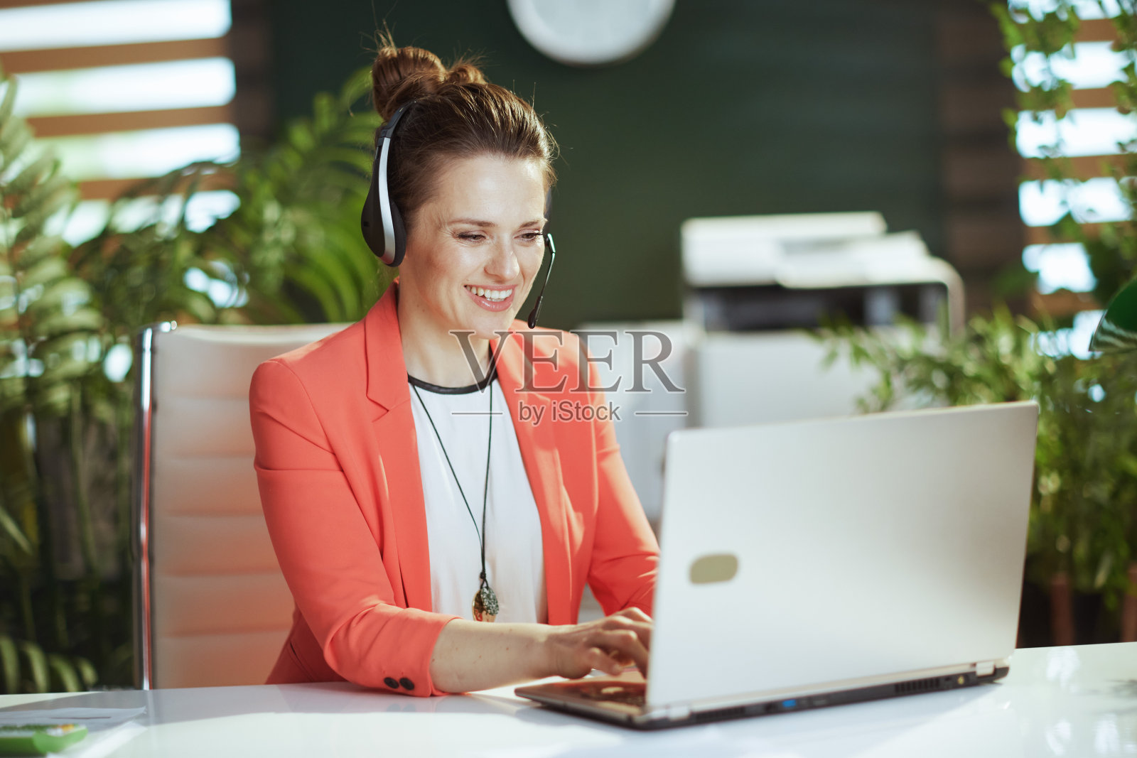 在绿色办公室里微笑的女企业主照片摄影图片