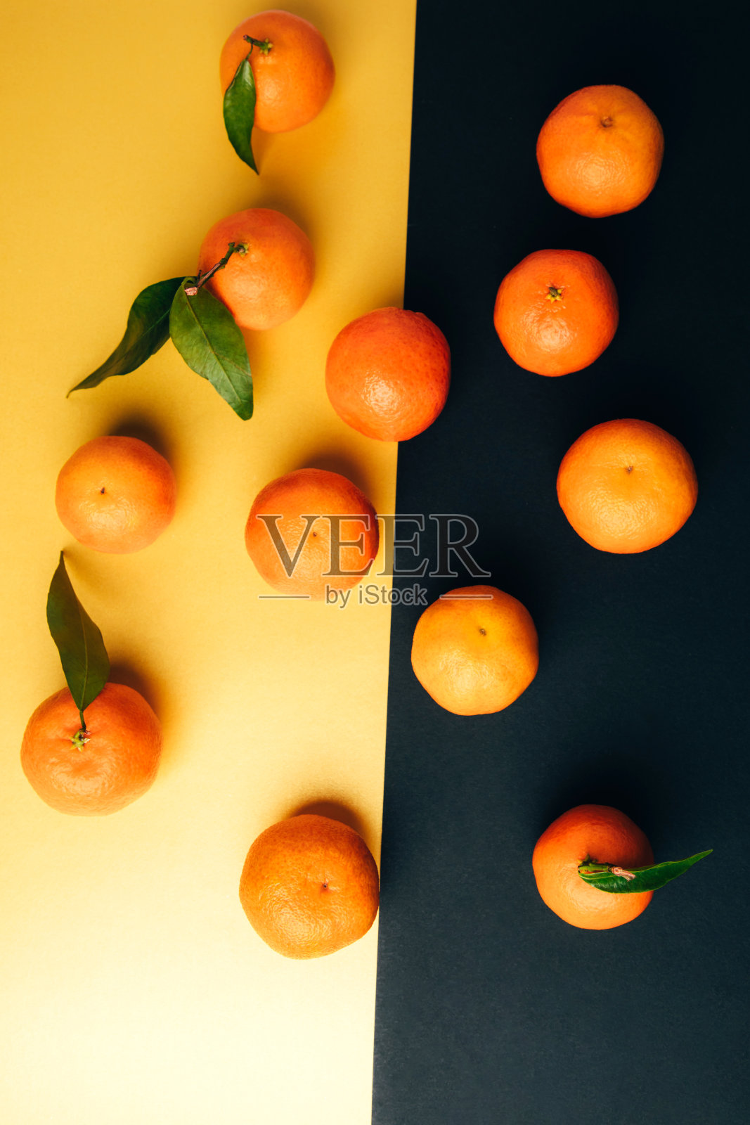 黄黑色背景上的绿叶柑橘照片摄影图片