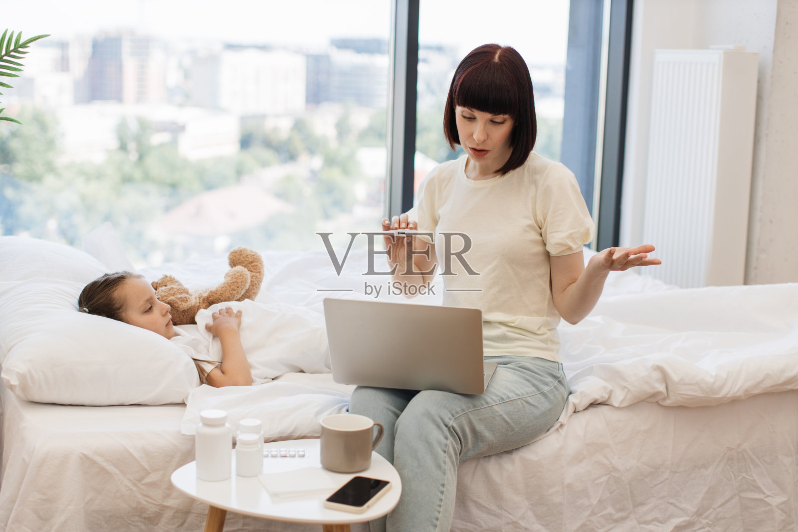 母亲在给孩子看病时用笔记本电脑进行视频预约照片摄影图片