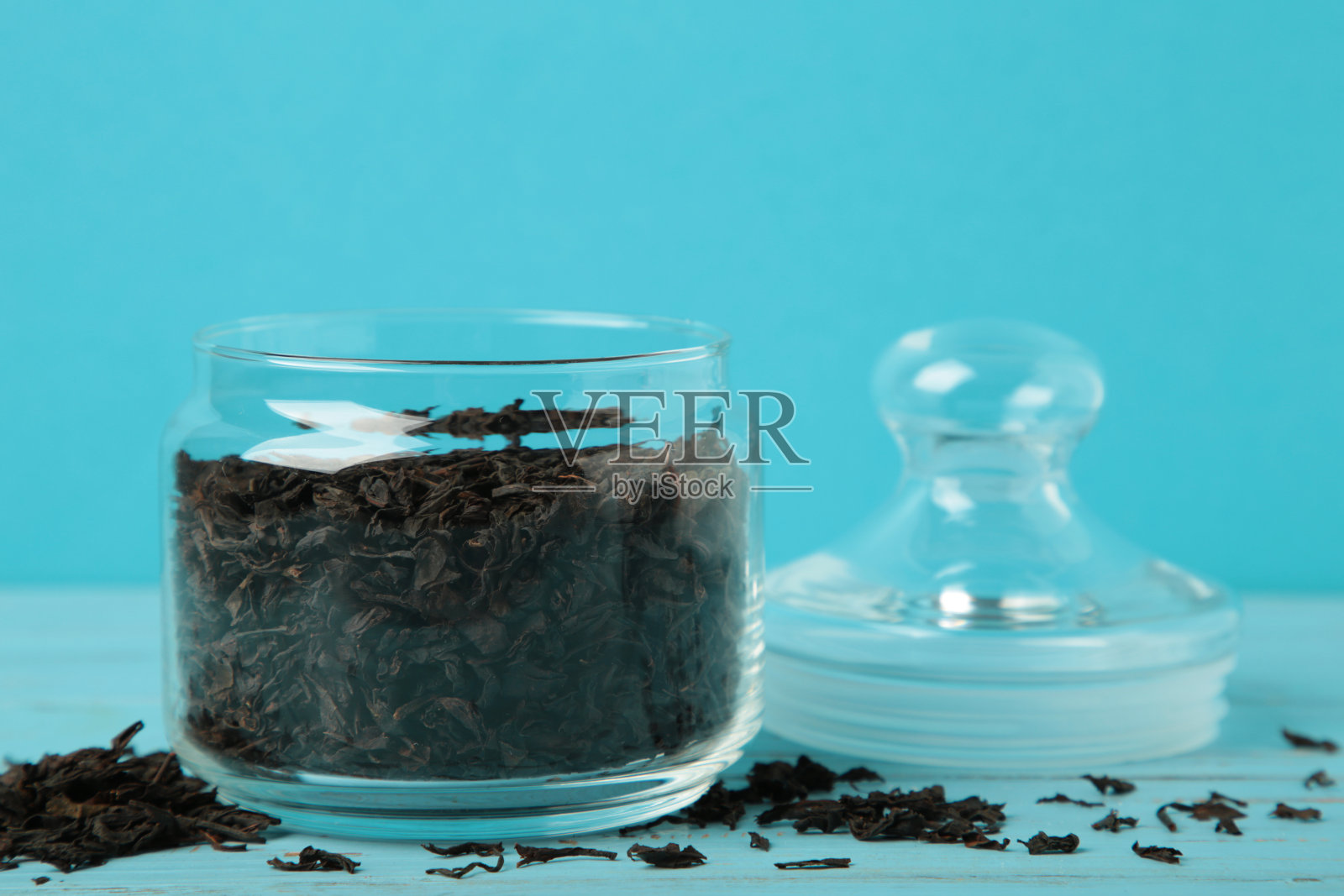 蓝色背景的茶叶大玻璃罐。照片摄影图片