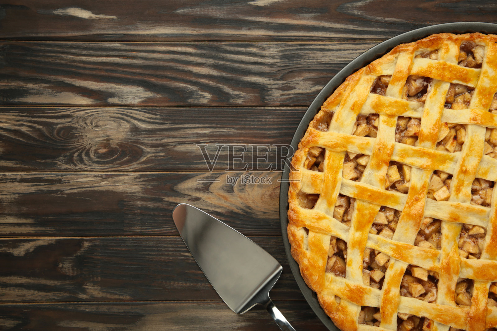 自制的甜美国苹果派,加糖和肉桂。在棕色背景下开始。照片摄影图片