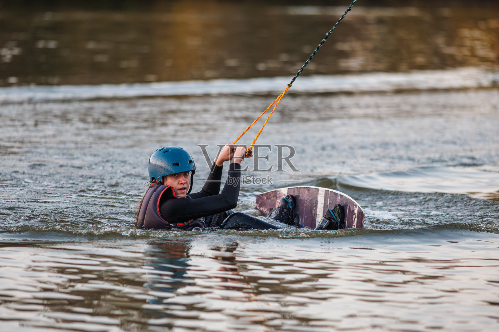 滑水板上的女孩。一名运动员在水上表演特技。秋天的公园照片摄影图片