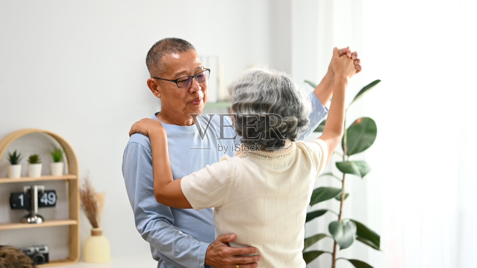深情的老年夫妇在客厅跳舞,享受退休生活,在家里度过闲暇时光照片摄影图片