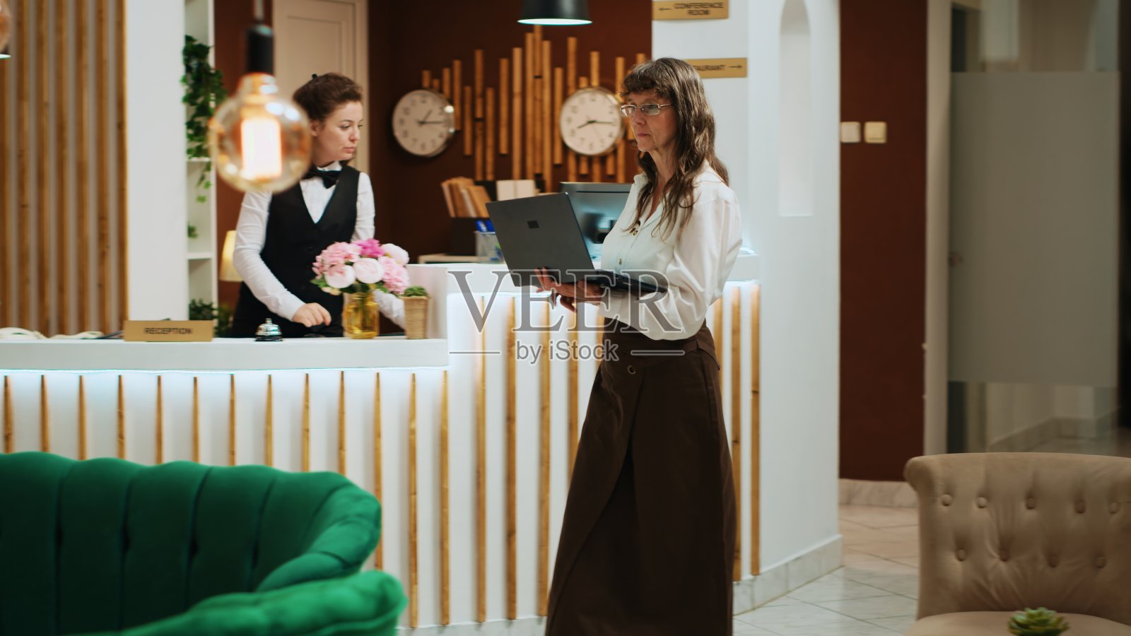 资深女士在大堂使用手提电脑照片摄影图片
