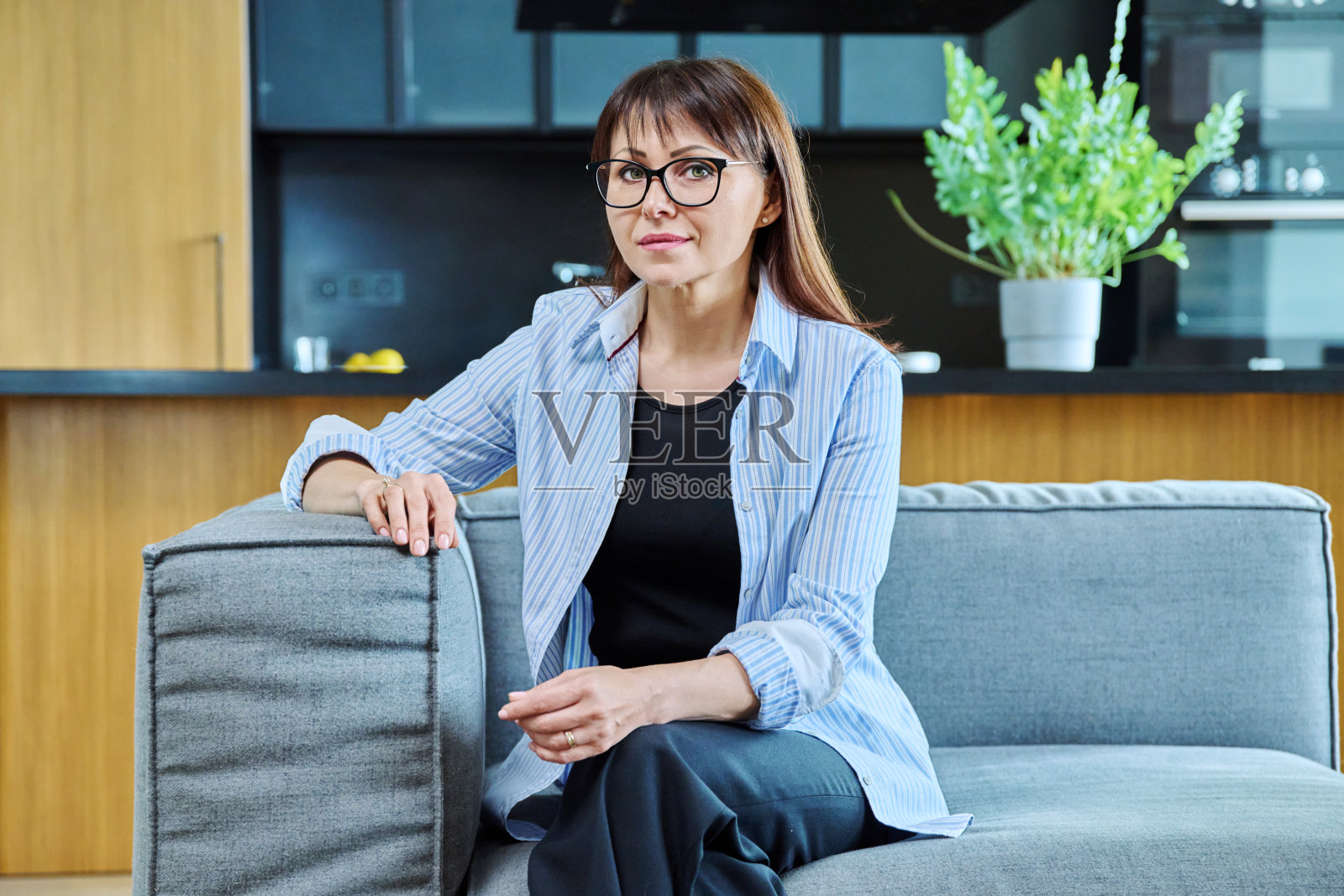 客厅室内沙发上优雅成熟女子的肖像照片摄影图片