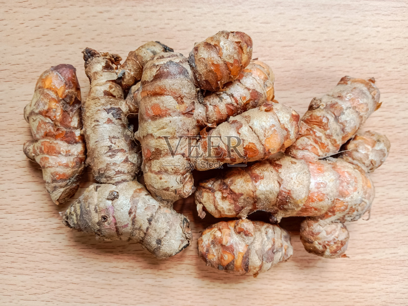 姜黄或姜黄。在木材背景上分离的姜黄。姜黄根。新鲜姜黄根。草本及药用植物。香料的概念。照片摄影图片