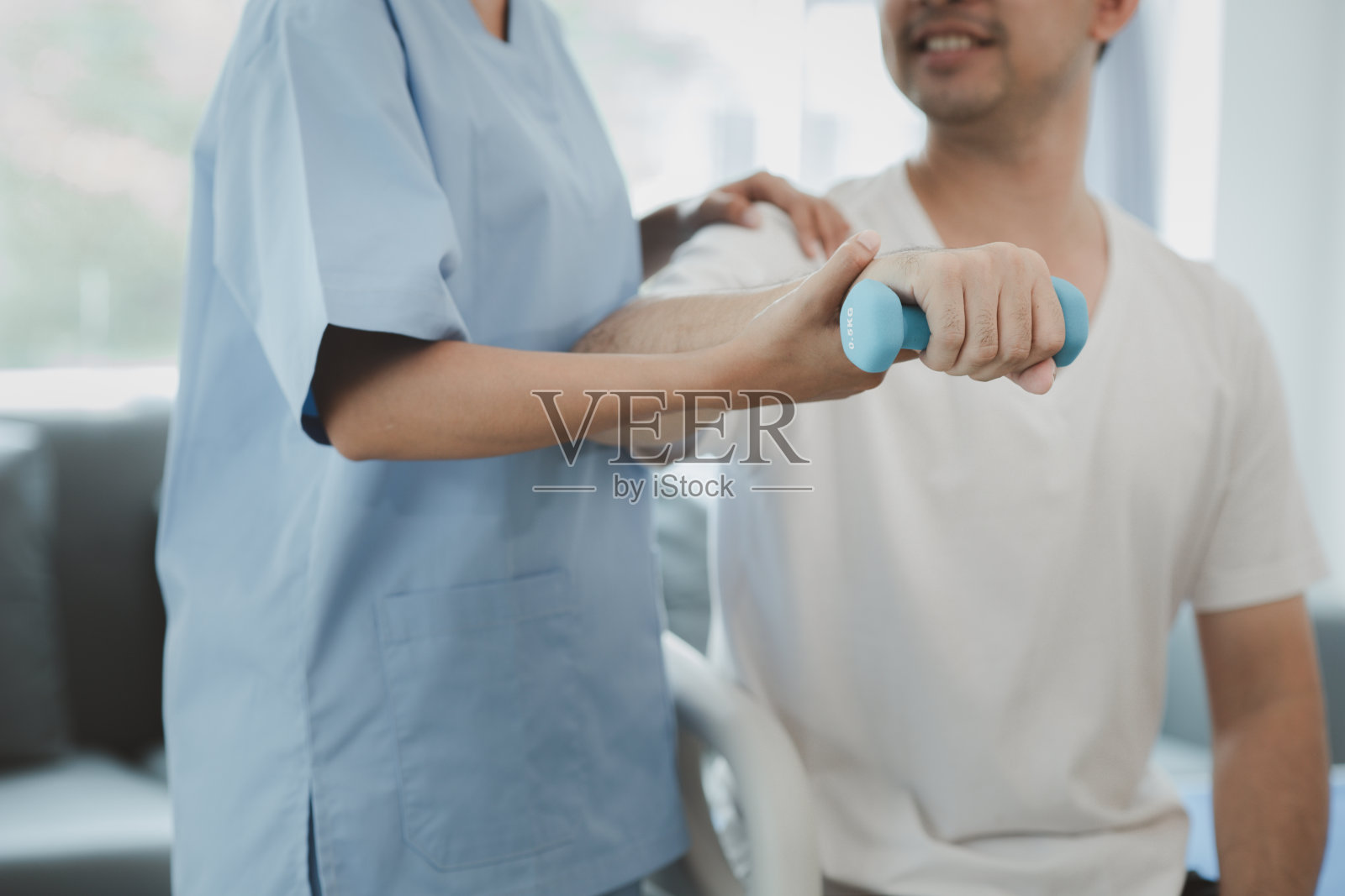 理疗师在病房里为病人做物理治疗,物理治疗通过运动身体和肌肉来帮助病人康复。用物理疗法治疗疾病的概念。照片摄影图片