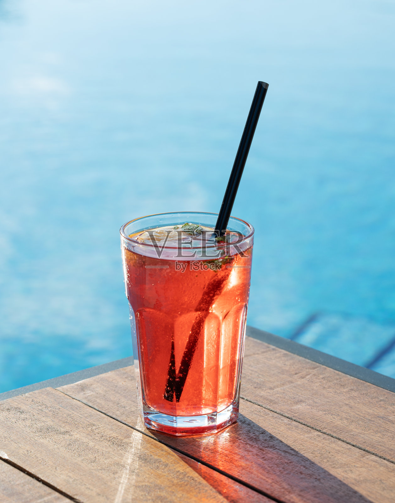 泳池前的木桌上放着新鲜的红莓莫吉托。夏日度假清凉饮料的概念。照片摄影图片