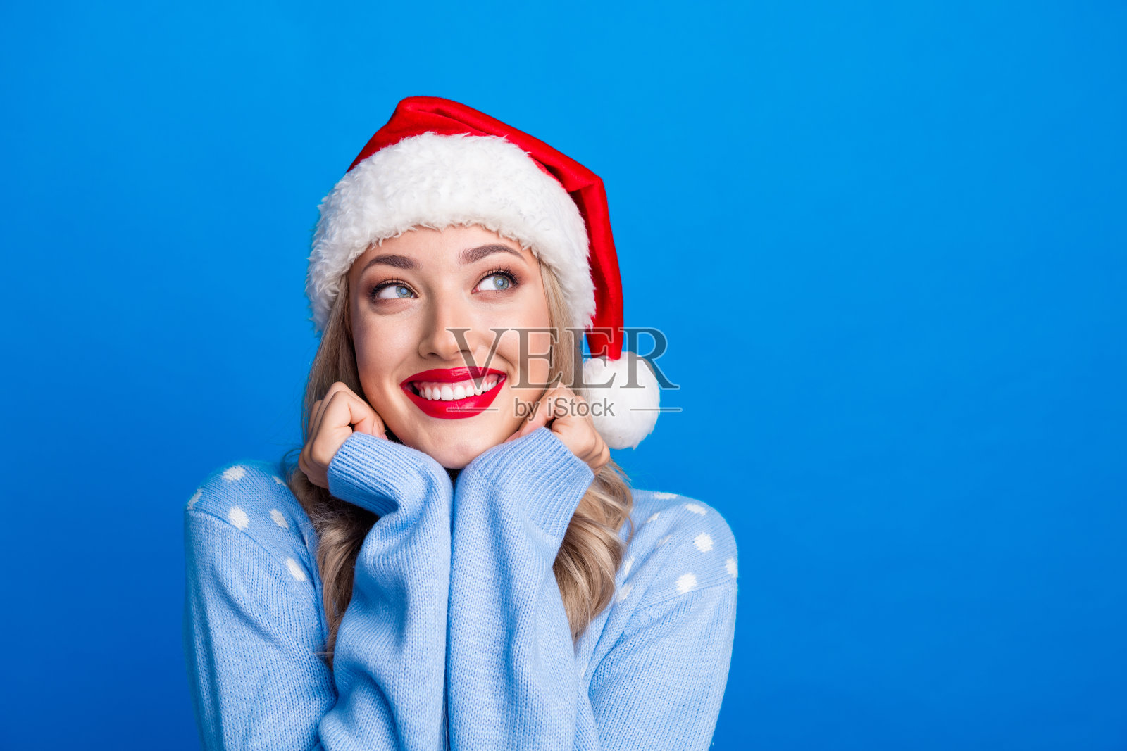 迷人的金发女郎的照片肖像欣赏看空空间穿毛衣圣诞帽孤立的蓝色背景照片摄影图片