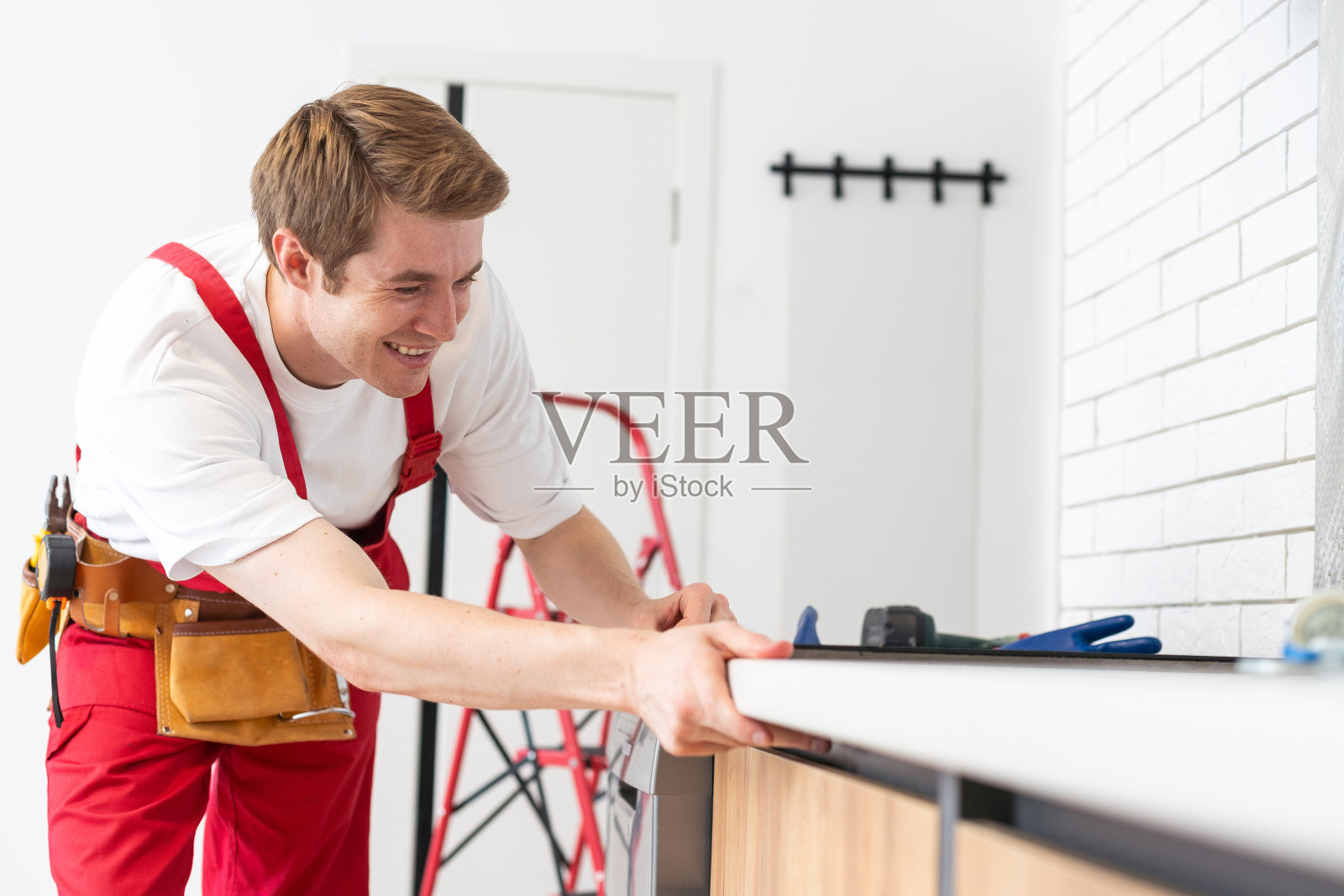 工匠在厨房安装滚刀。家电安装服务理念。照片摄影图片