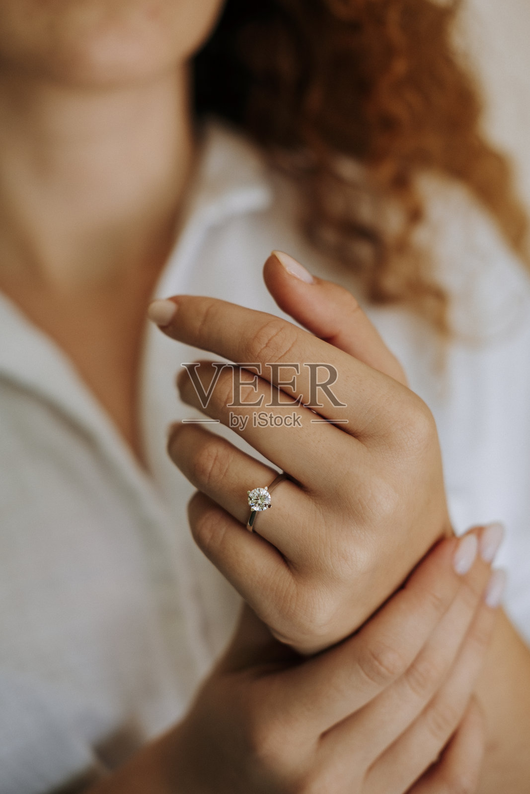 手指上戴着钻戒的女人。照片摄影图片