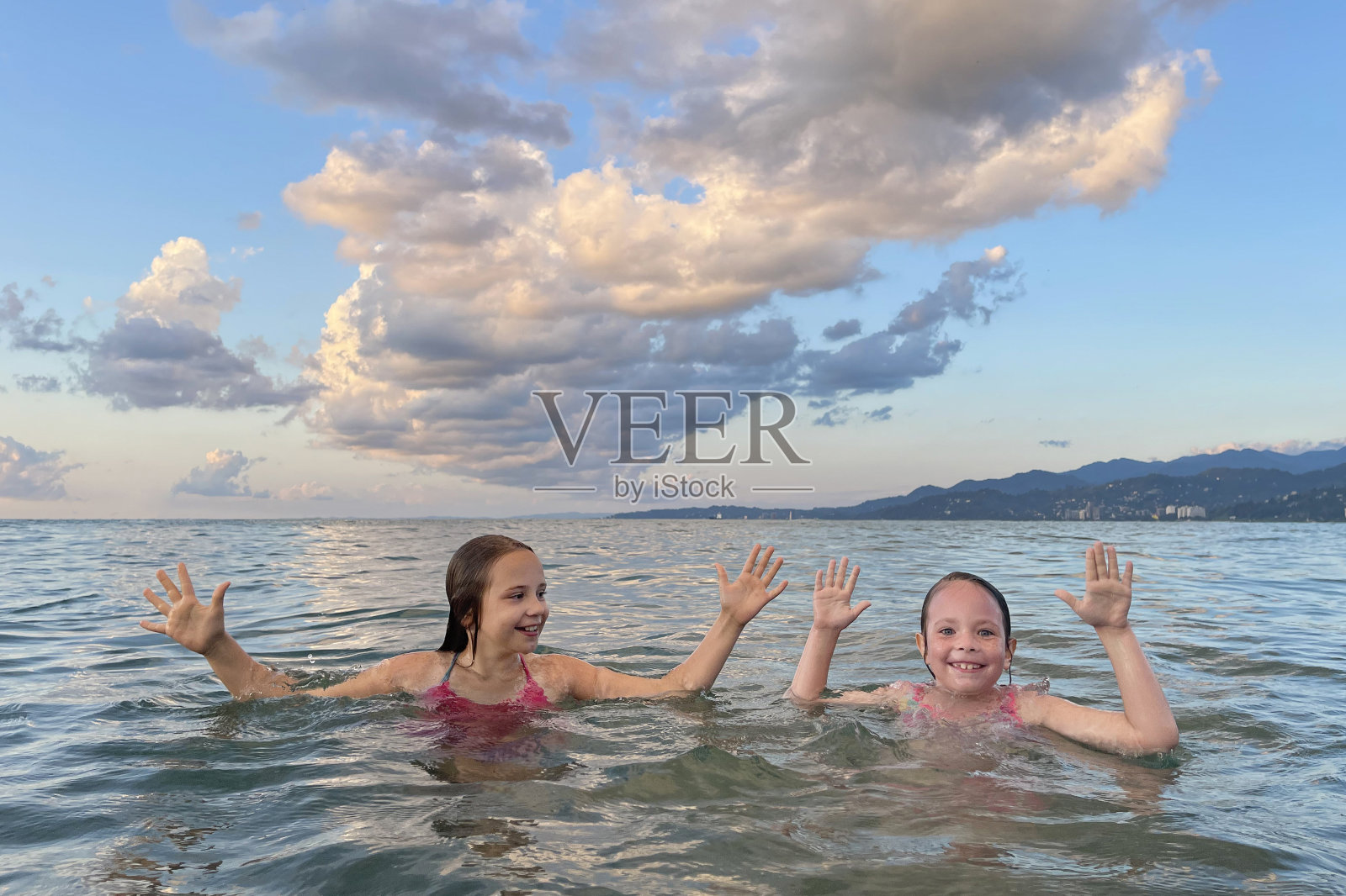 快乐的小女孩在暑假里玩得很开心。孩子在海里玩耍。健康生活理念。夏日少女画像照片摄影图片