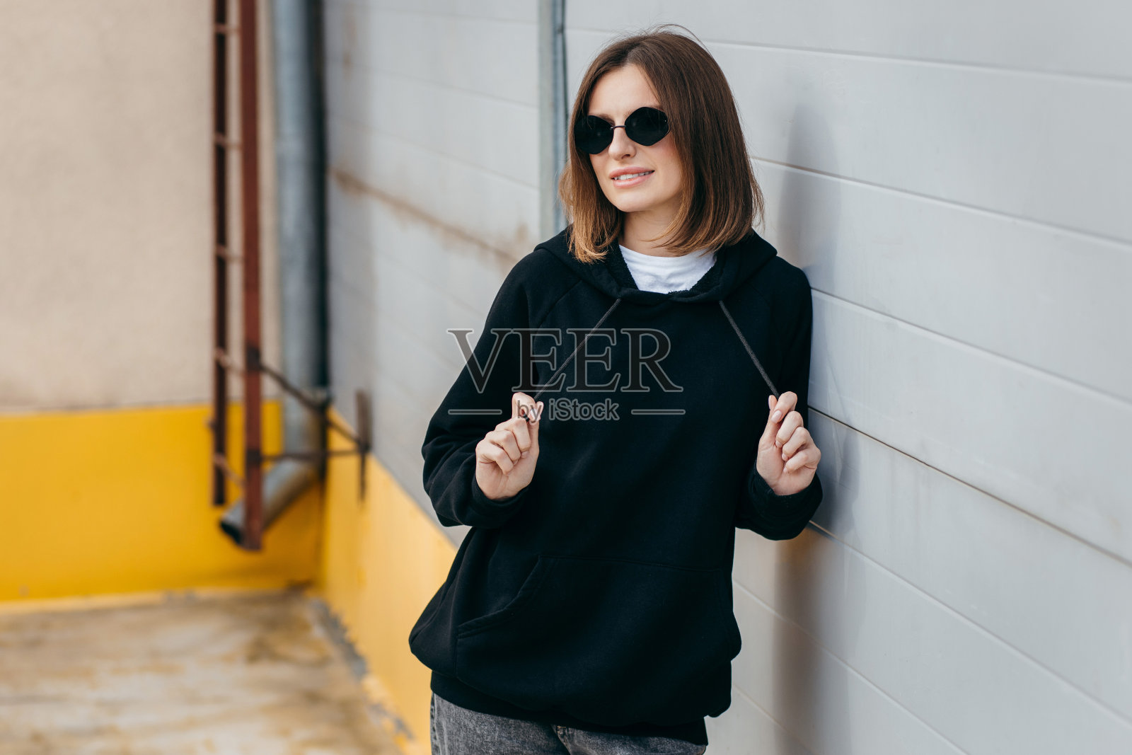 戴眼镜,穿黑色连帽衫的年轻女子照片摄影图片