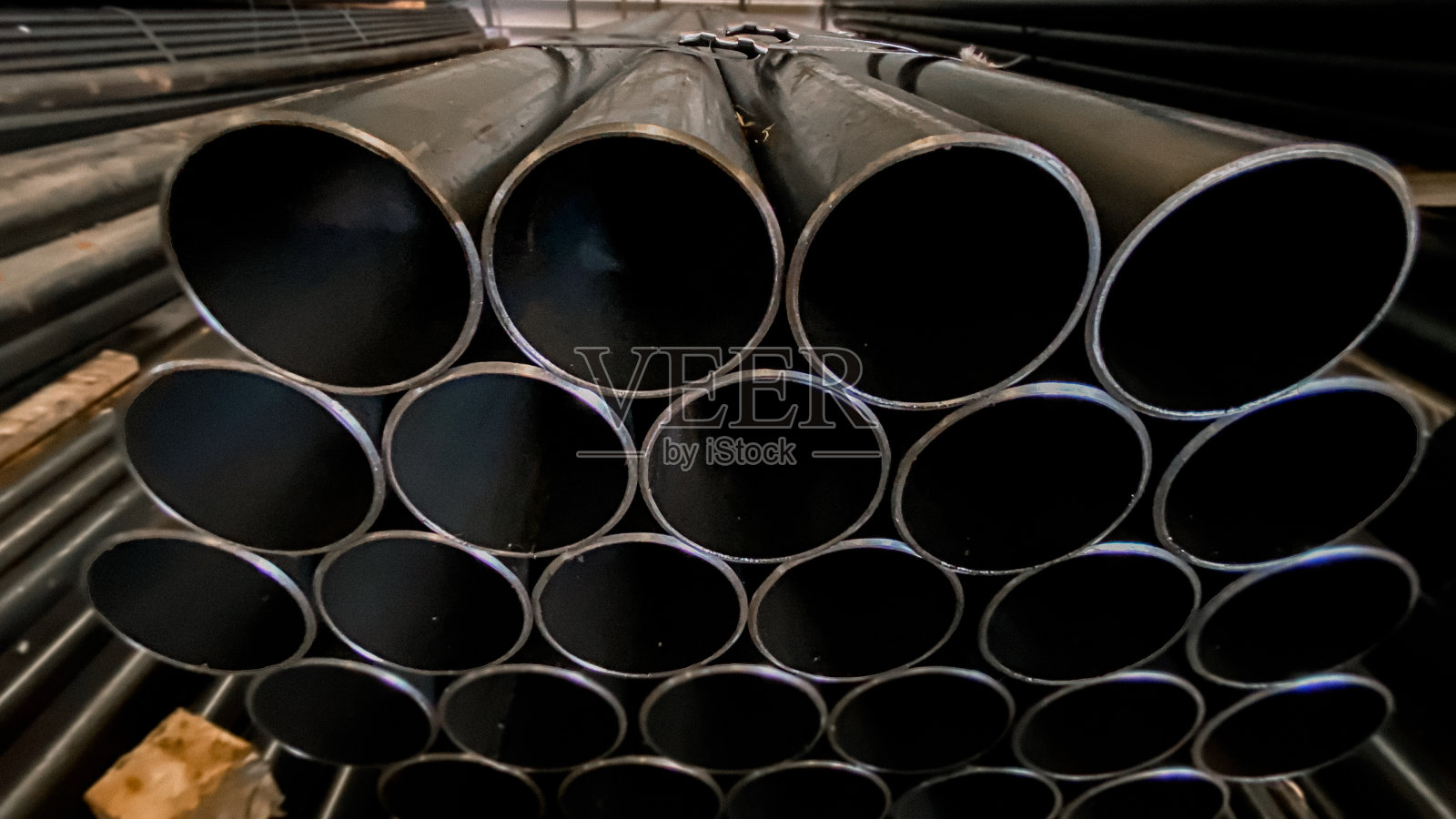 钢管在工厂内放置,用于制造的钢管,堆放在一起的钢管,特写。钢管在仓库里等待交货。在泰国照片摄影图片