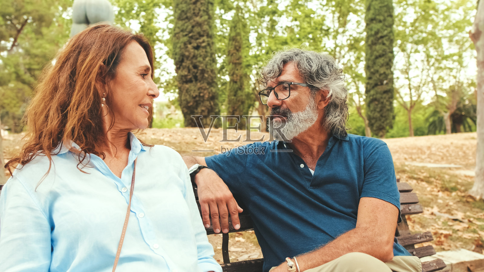 秋天,一对恩爱的夫妇坐在公园外面聊天照片摄影图片