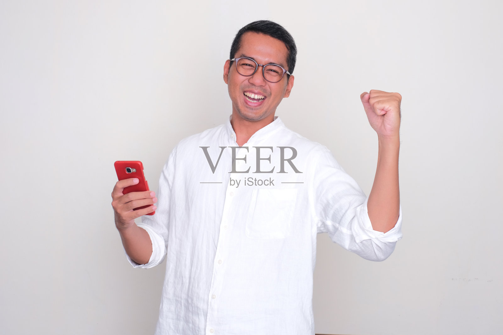 亚洲成年男子手持手机欢呼雀跃照片摄影图片