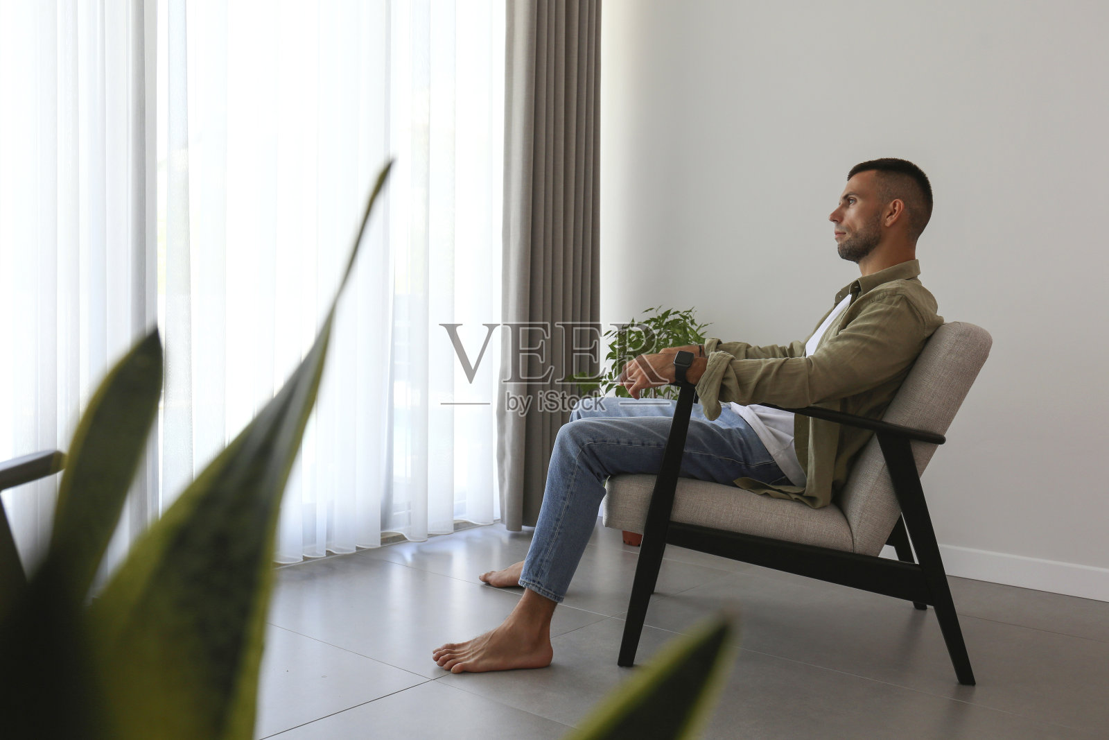 中年男子独自坐在家里。照片摄影图片