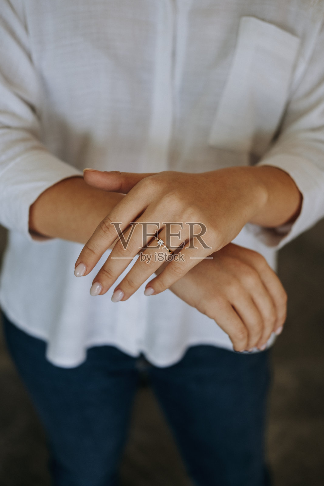 手指上戴着钻戒的女人。照片摄影图片