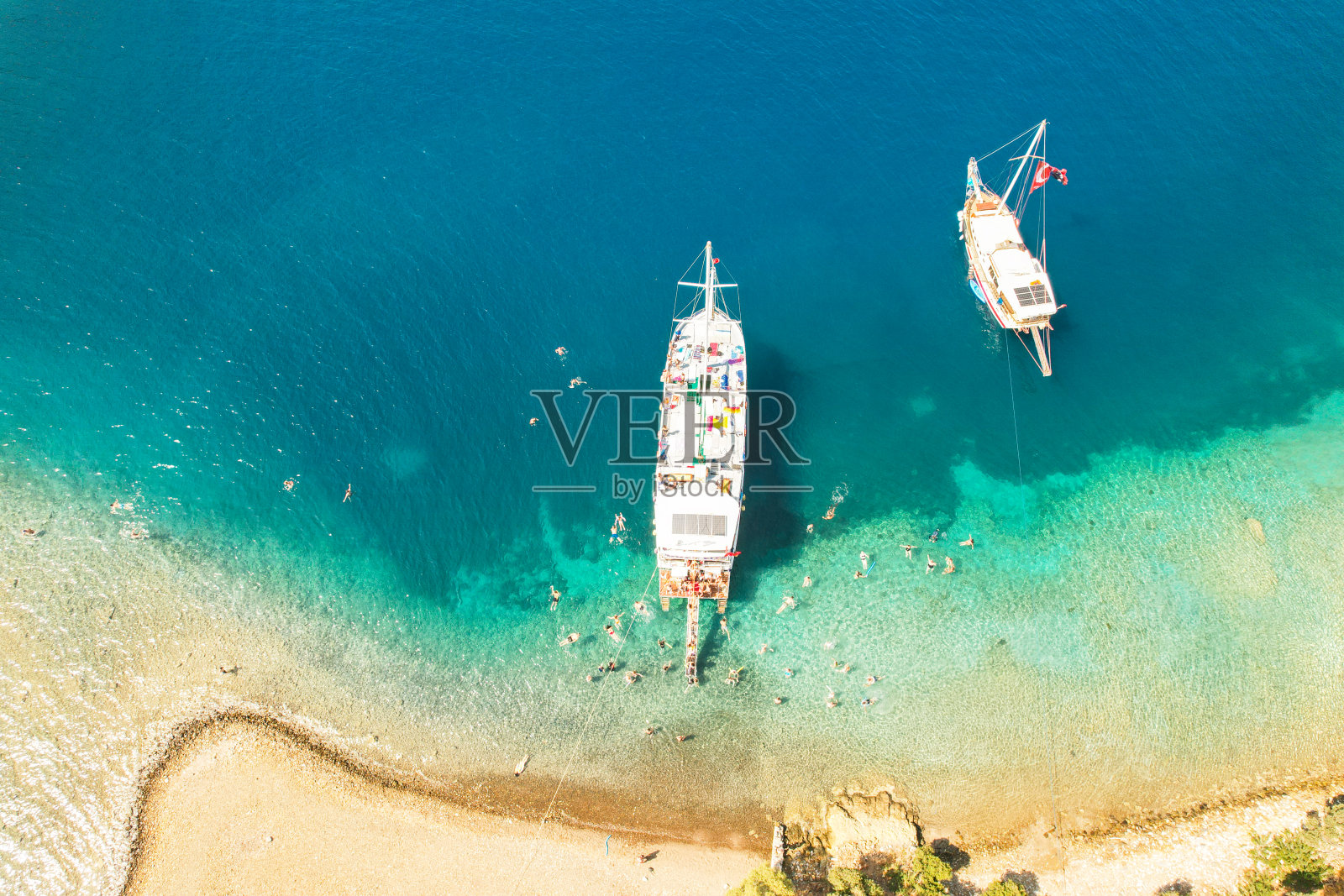 鸟瞰美丽的游艇在海上和岩石在夏天日落在土耳其。船的俯视图,石头,清澈的蓝色海水。热带景观。旅行。自然背景。从上面看。巡航照片摄影图片