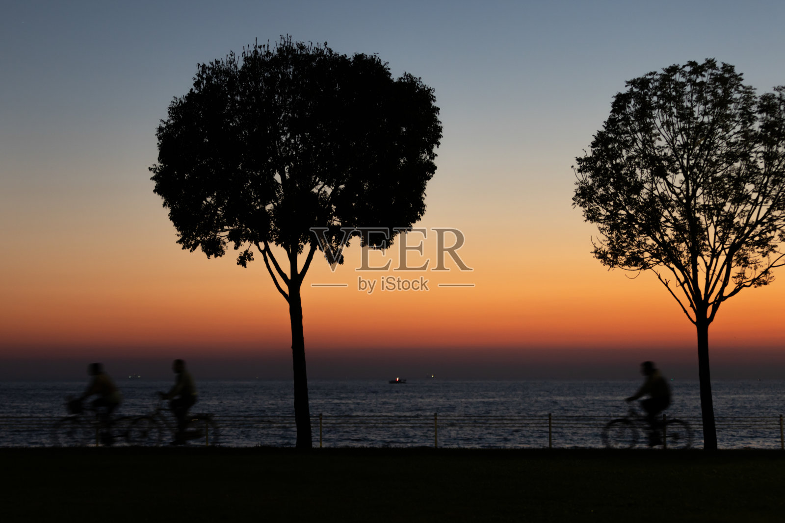 日落时的人物和树木轮廓照片摄影图片