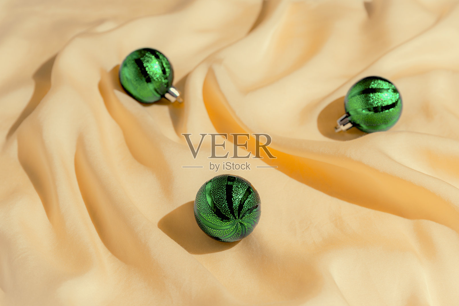 极简风格组成的绿色装饰小玩意在柔和的橙色绸片作为背景。圣诞节和新年的概念照片摄影图片