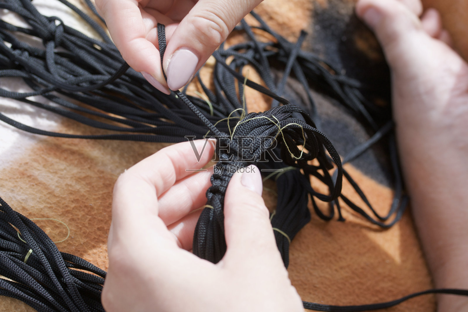 柳条购物袋。一个女人在编织一个细绳袋。照片摄影图片