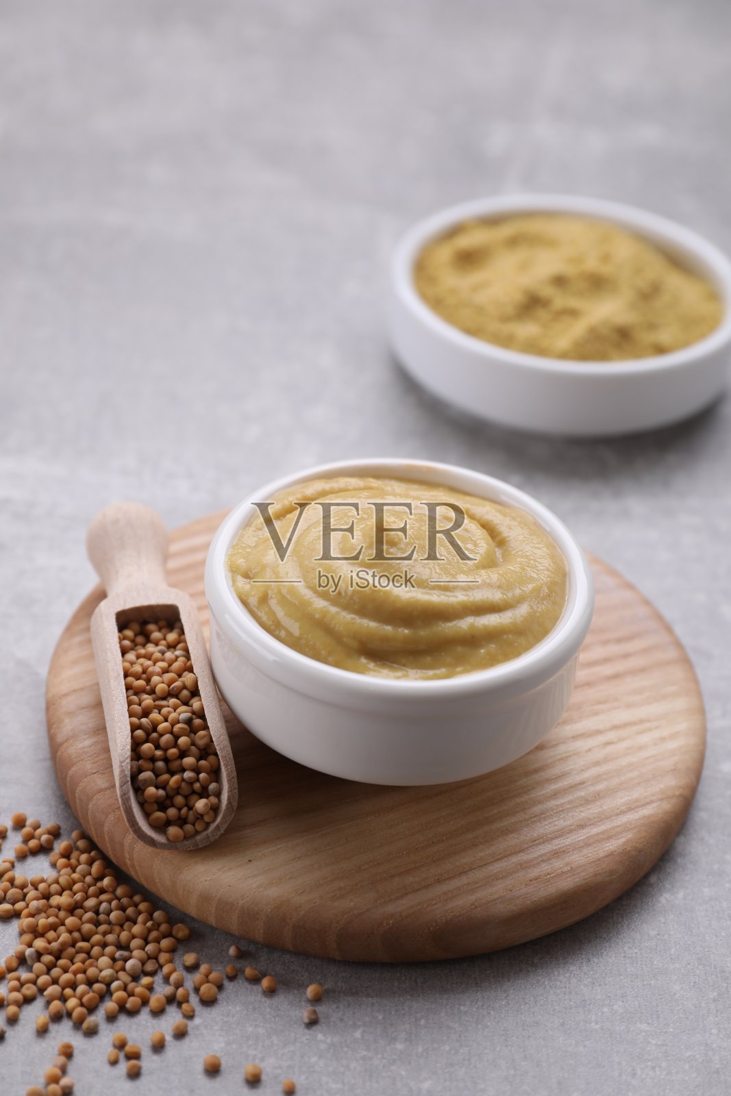 浅灰色的桌子上有美味的芥末和种子照片摄影图片