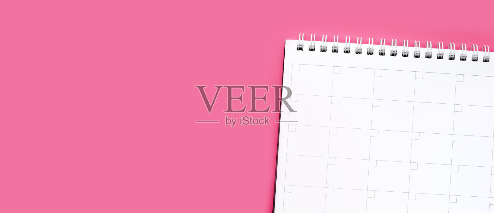 粉红色背景的日历书。工作计划照片摄影图片