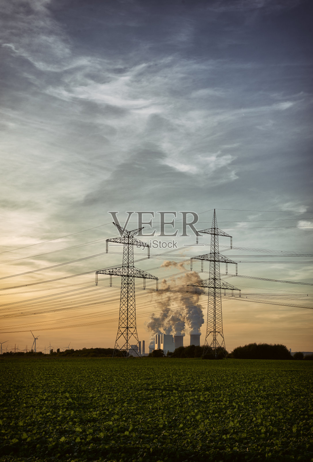 电力塔的剪影和两个污染的发电厂照片摄影图片