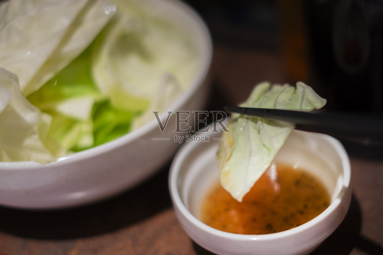 用筷子吃生卷心菜。照片摄影图片