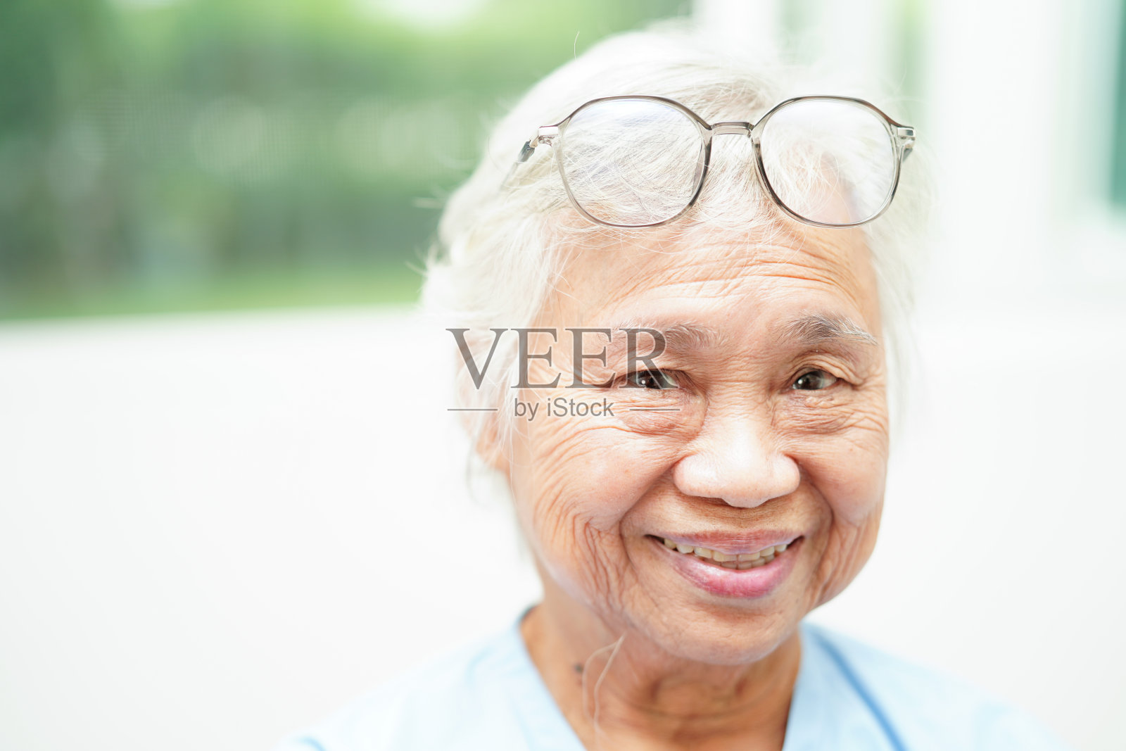 亚洲老年妇女配戴眼镜或视力眼镜在家护理服务。照片摄影图片